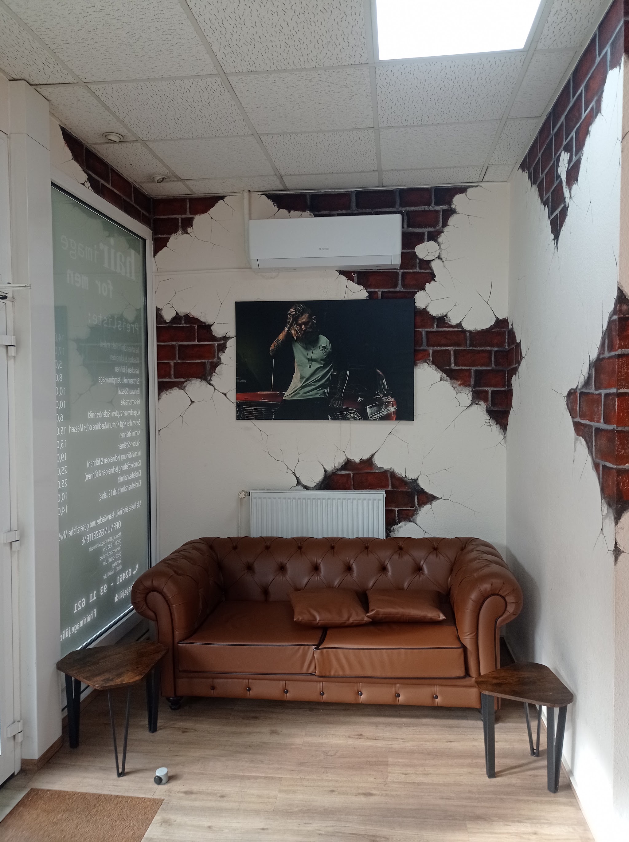 Wartebereich im Hair Image Barbershop mit Chesterfield-Sofa und Ziegel-Deko